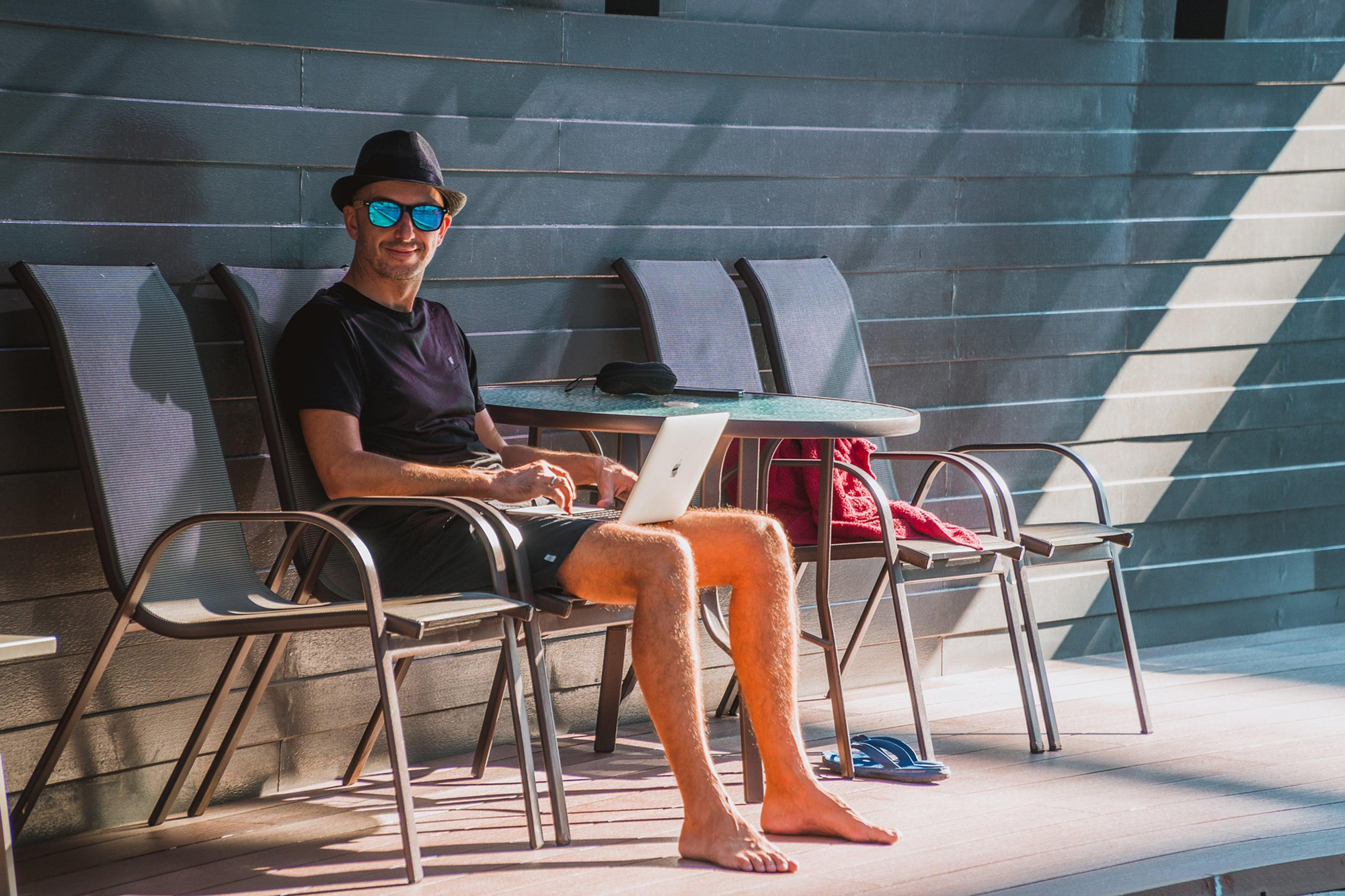 Man with hat and wearing glasses working on decking