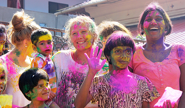 Girls volunteer in India with colour festival and covered in powder