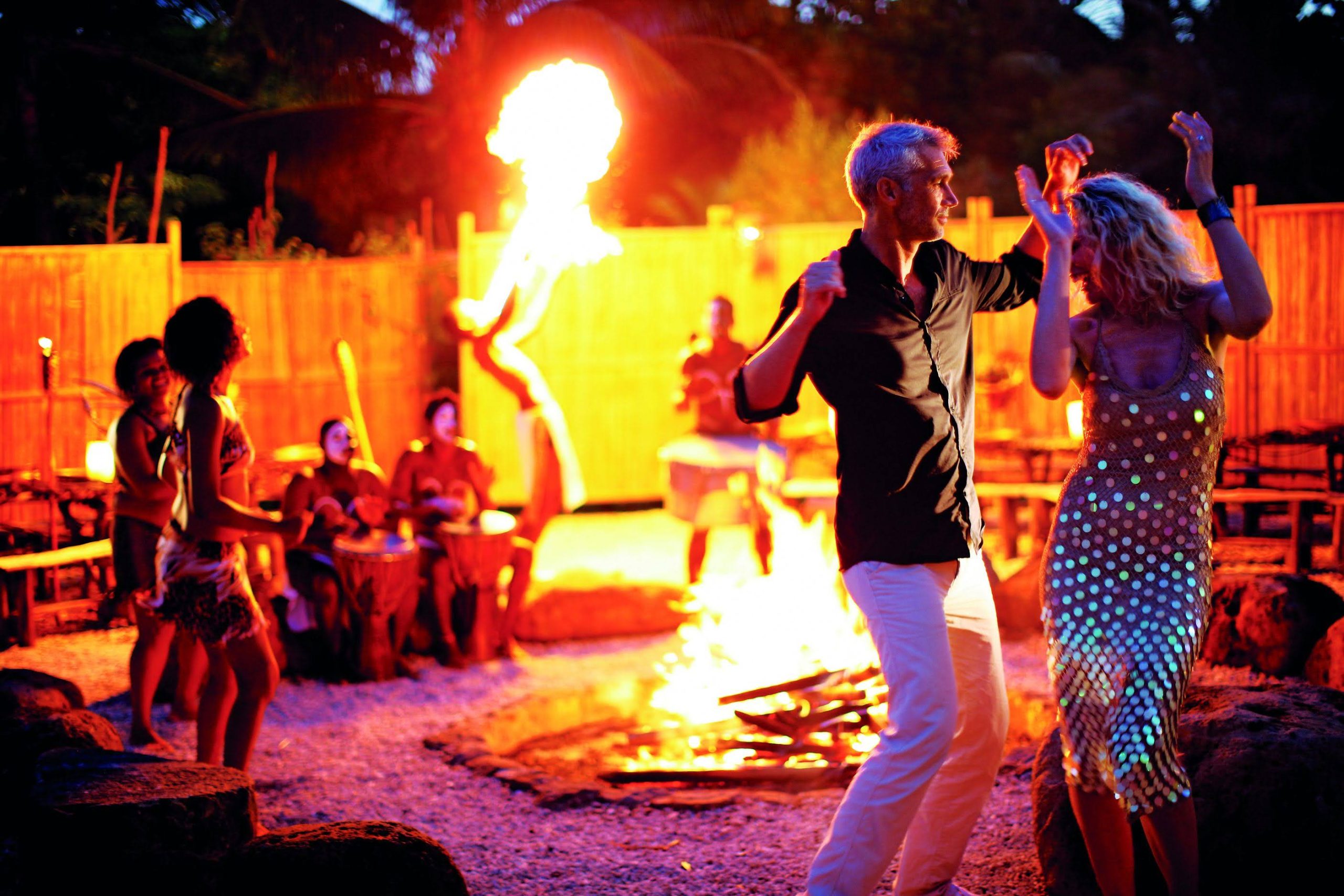 People dancing around a Boma camp fire on holiday.