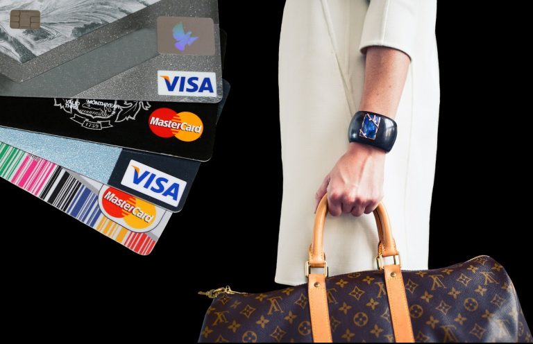 Hand holding designer bag with bank cards